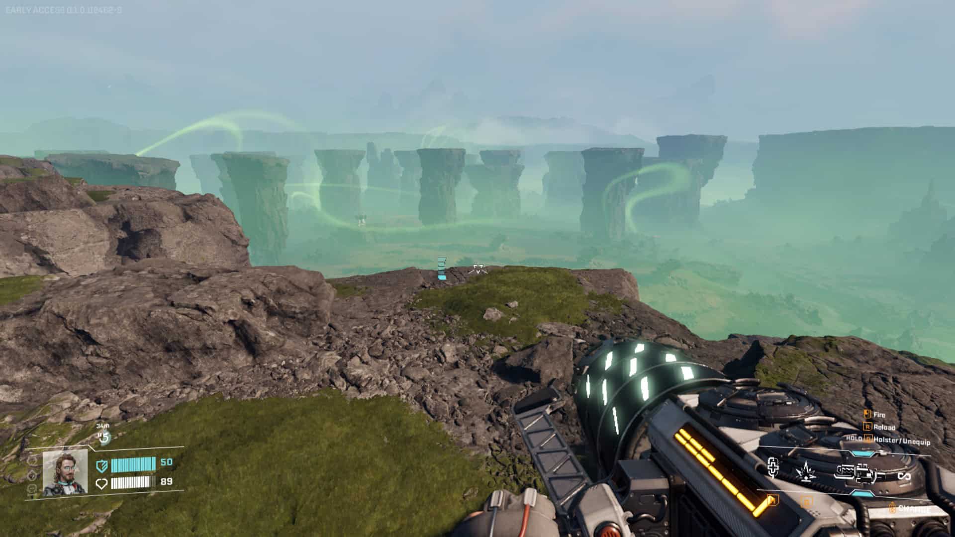 A nearby valley containing a green glowing energy and a number of natural rocky pillars sticking up; a mining laser is held at the ready
