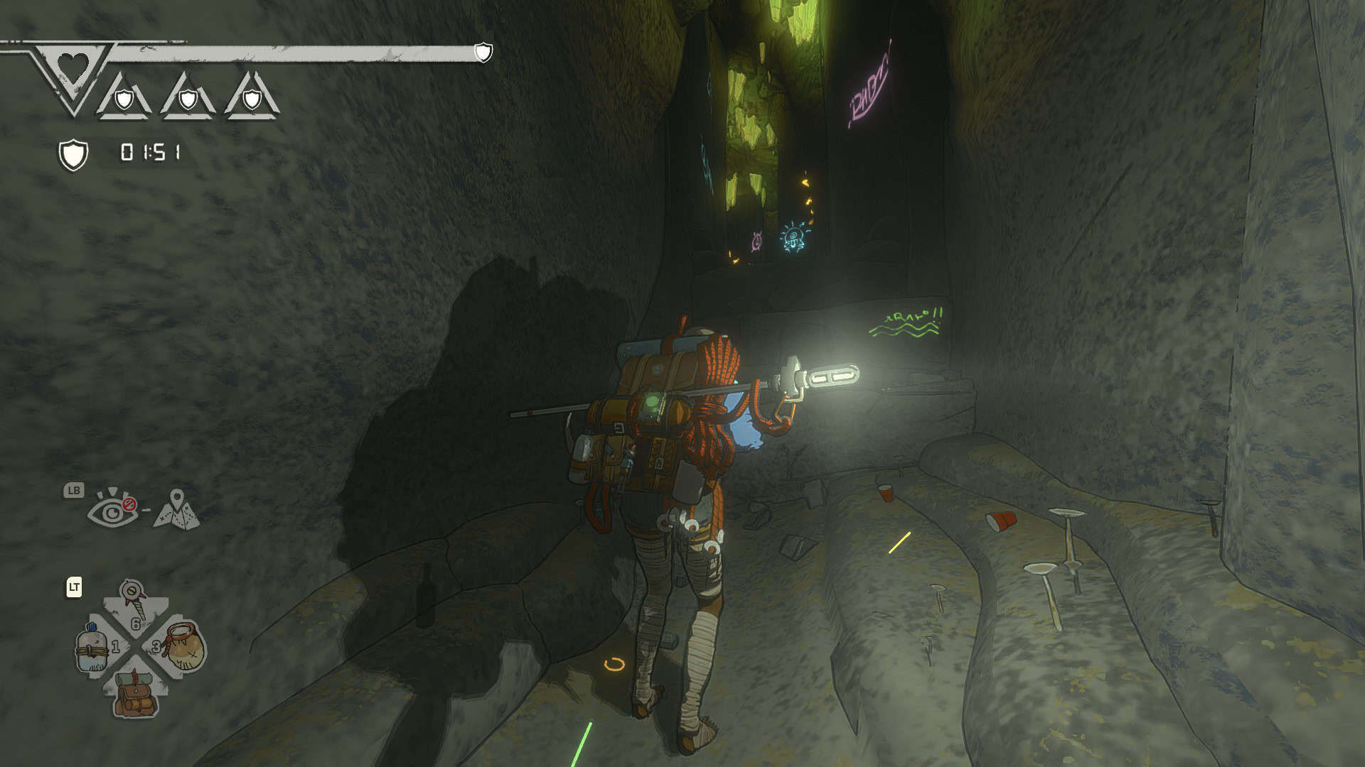 Aava in a cave, with a bright light on her backpack and some luminescent graffiti on the walls