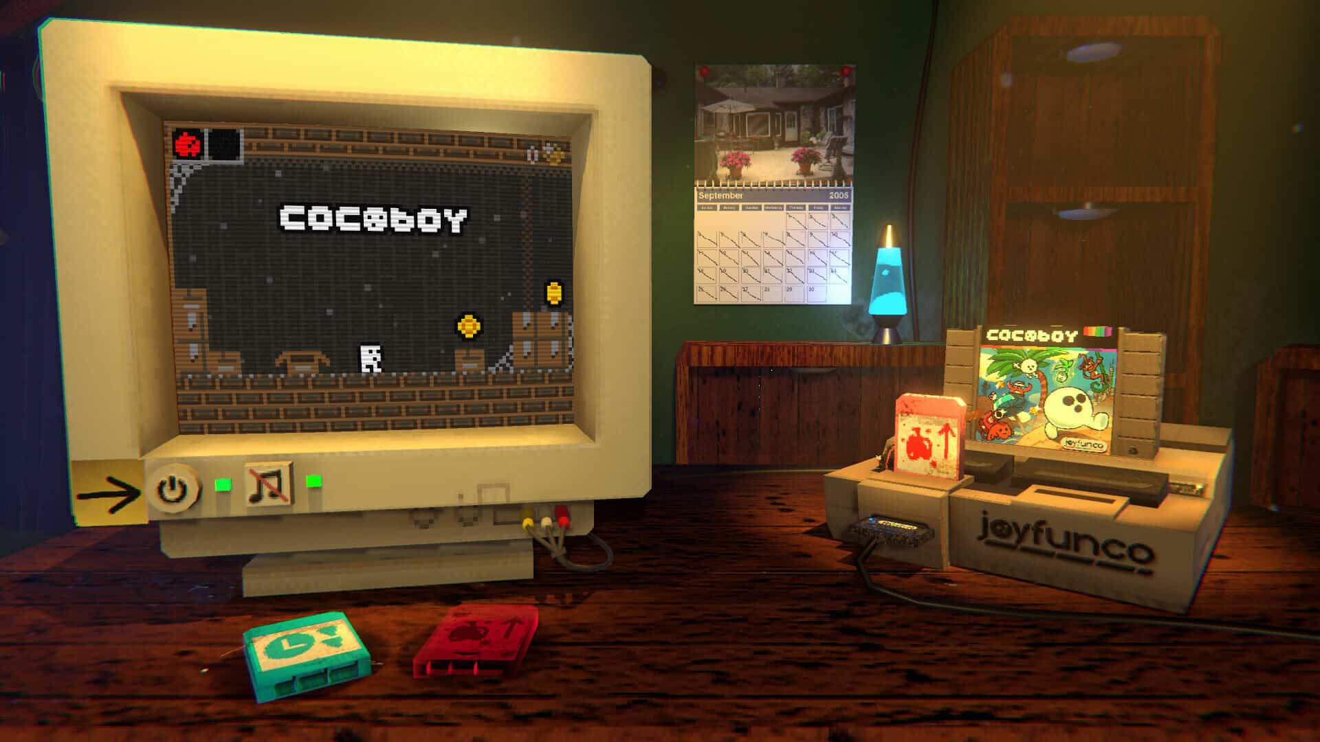 A computer screen with the game Cocoby, a console on the right and some cartridges on the table