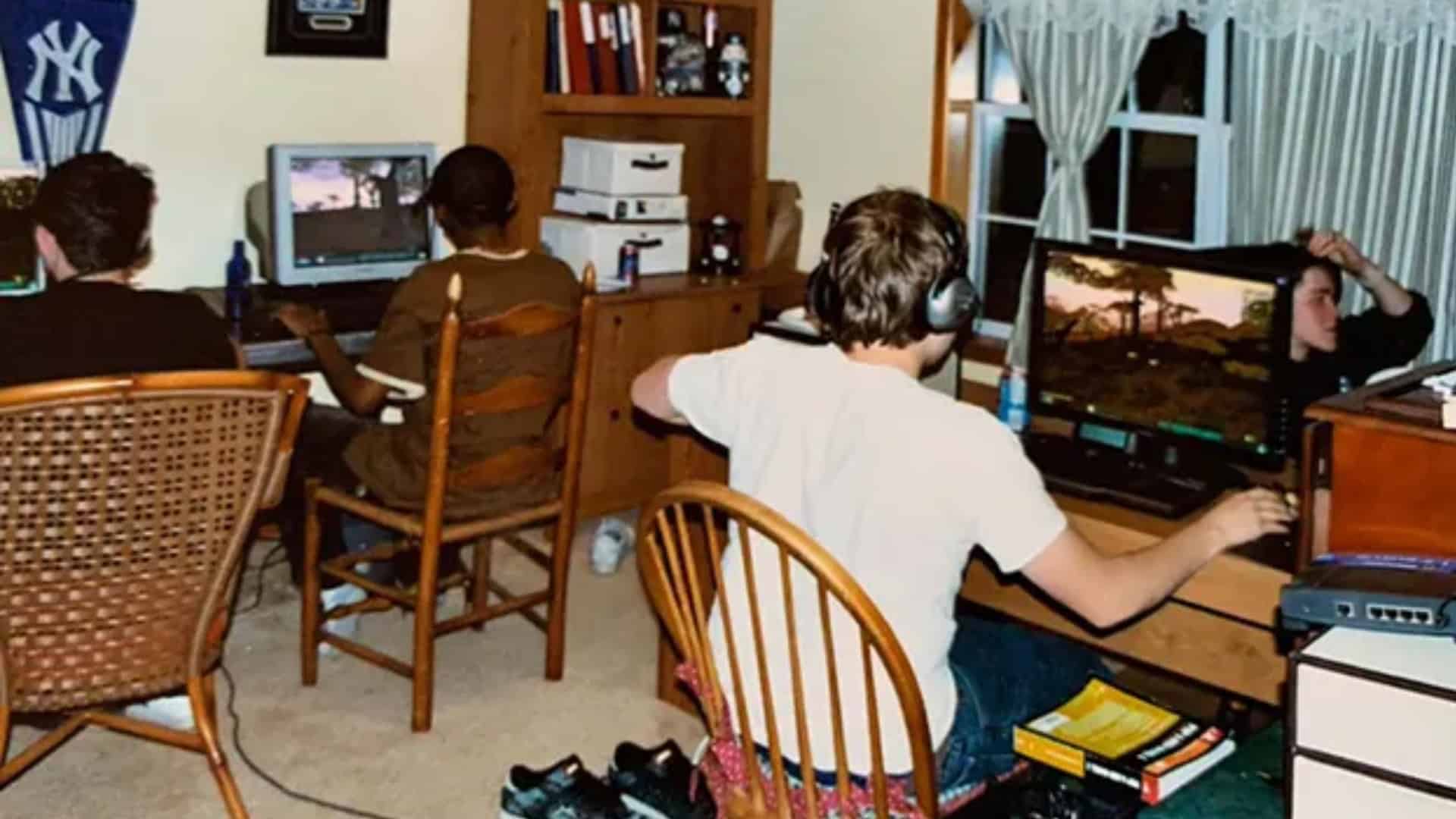A LAN party from the early 2000s, featuring teenagers at separate consoles or PCs around a bedroom.