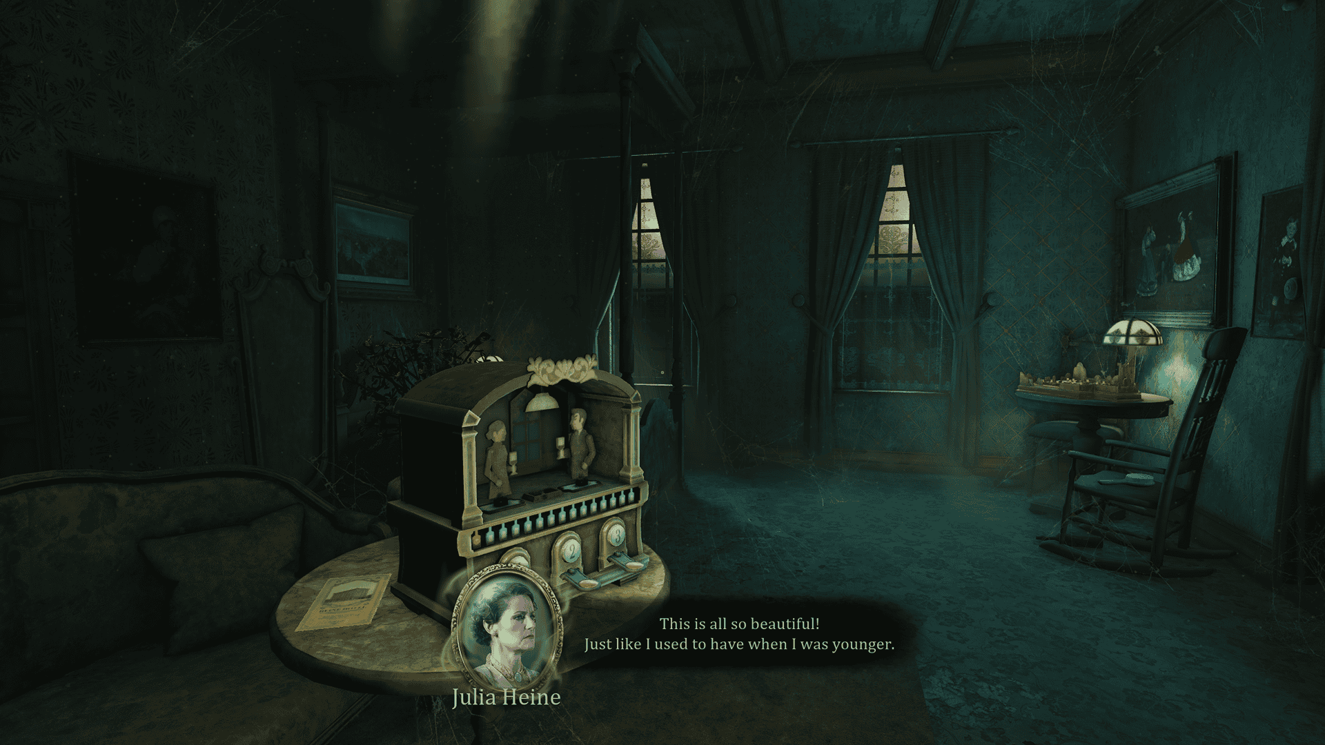 A dusty, cobwebbed room that is mostly dark. Along the far wall there are windows, through which you can see dark skies and rain. Along the far wall is a bed and a table with a rocking chair next to it. On the table is some kind of game. In the foreground is a settee with a table in front of it. Facing the viewer on the table is a small game resembling a puppet theater with three buttons labeled 1, 2, and 3. There are two characters in the theater, a woman and a man with red eyes. Behind the game is a pamphlet. A caption below reads: "Julia Heine: This is all so beautiful! Just like I used to have when I was younger."