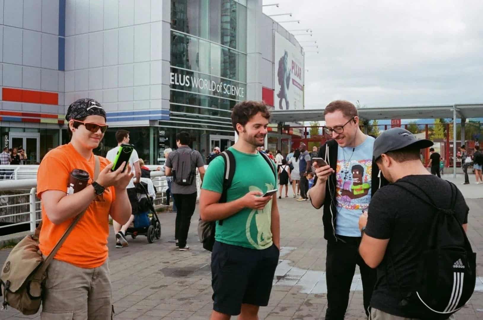 A group of friends looking at their phones during the Pokémon Go Community Day in 2020